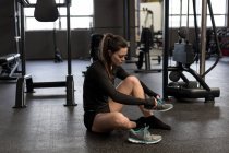 Schöne Frau mit Schuhen im Fitnessstudio — Stockfoto