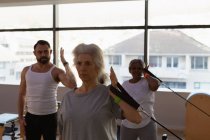 Тренер инструктирует группу пожилых женщин во время выполнения упражнений в центре йоги — стоковое фото