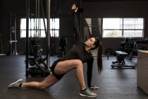 Adatta donna che fa esercizio di stretching in palestra — Foto stock