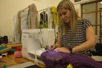 Designer de moda bonita usando máquina de costura no estúdio de moda — Fotografia de Stock