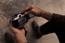 Чоловік-фотограф тримає камеру в фотостудії — стокове фото