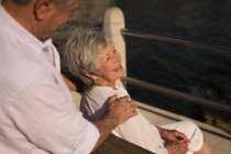 Couple âgé assis sur un banc près de la mer à la promenade — Photo de stock