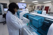 Tecnico di laboratorio attento che utilizza la macchina in banca del sangue — Foto stock
