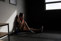 Woman talking on mobile phone in fitness studio — Stock Photo