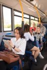 Female commuter using digital tablet while travelling in modern bus — Stock Photo
