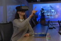 Бізнес-леді, використовуючи гарнітуру віртуальної реальності в конференц-залі в офісі — стокове фото