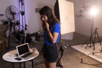 Жіноча модель дивиться на цифрову камеру в фотостудії — стокове фото
