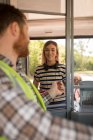 Female commuter taking ticket from driver in modern bus — Stock Photo