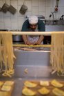 Уважний чоловічий пекар готує макарони в хлібопекарні — стокове фото