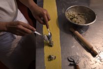 Seção média de padeiro preparando macarrão na padaria — Fotografia de Stock
