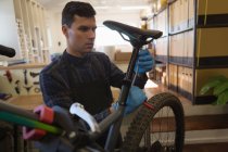 Человек регулирует сиденье велосипеда с гаечным ключом в мастерской — стоковое фото