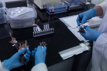 Sezione intermedia dei tecnici di laboratorio che tengono le etichette nella banca del sangue — Foto stock