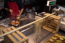 Klapptrockner frische Pasta während Bäcker in Bäckerei zubereitet — Stockfoto