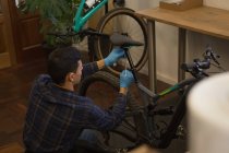 Rare View de homem ajustando assento de bicicleta com chave na oficina — Fotografia de Stock