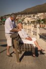 Couple aîné souriant embrassant près du bord de mer à la promenade — Photo de stock