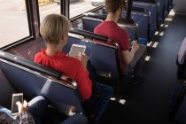 Overhead of female commuter using digital tablet while travelling in modern bus — Stock Photo