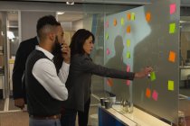 Empresários discutindo sobre notas pegajosas no escritório — Fotografia de Stock
