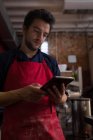 Чоловічий пекар використовує цифровий планшет у пекарні — стокове фото