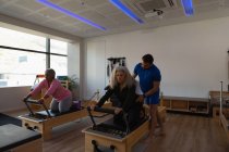 Trainerin unterstützt ältere Frauen beim Yoga im Yoga-Zentrum — Stockfoto