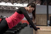 Fit woman doing push up exercise in fitness studio — Stock Photo