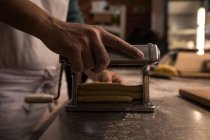 Bäcker setzt Maschine zur Zubereitung von Pasta in Bäckerei ein — Stockfoto