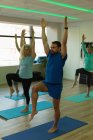 Formateur aidant les femmes âgées à effectuer du yoga au centre de yoga — Photo de stock