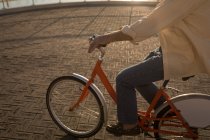 Sección baja de hombre mayor montar en bicicleta en el paseo marítimo - foto de stock