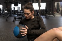 Beautiful woman doing oblique exercise in fitness studio — Stock Photo