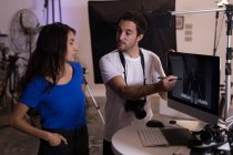 Male photographer and female model interacting with each other in photo studio — Stock Photo