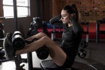 Hermosa mujer haciendo ejercicios abdominales en un gimnasio de fitness - foto de stock