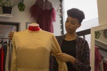 Fashion designer adjusting dress of mannequin in fashion studio — Stock Photo