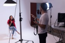 Fotografo maschile e modella femminile che interagiscono tra loro in studio fotografico — Foto stock