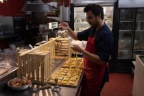 Bäcker bereitet handgemachte Nudeln in Bäckerei zu — Stockfoto