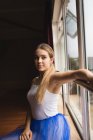 Nachdenkliche Ballerina sitzt am Fenster im Atelier — Stockfoto