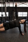 Mujer joven haciendo ejercicio de tablón lateral en el gimnasio - foto de stock