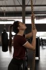 Молода жінка робить вправи для скелелазіння в тренажерному залі — стокове фото