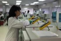 Técnico de laboratorio usando dispositivo electrónico en banco de sangre - foto de stock