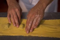 Close up de padeiro macho preparando macarrão na padaria — Fotografia de Stock