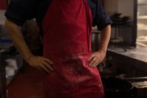 Чоловічий пекар стоїть руками на стегні в пекарні — стокове фото