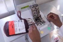 Лаборант анализирует пакеты крови в банке крови — стоковое фото