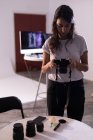 Modelo femenino revisando fotos en cámara digital en estudio fotográfico - foto de stock