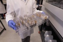 Técnico de laboratorio sosteniendo tubos de ensayo en banco de sangre - foto de stock