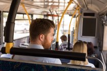 Hombre inteligente viajando en autobús moderno - foto de stock