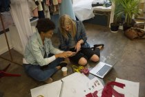 Diseñador de moda usando tableta digital en estudio de moda - foto de stock