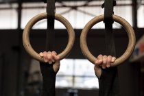 Fit woman exercising on gymnastic rings in fitness gym — Stock Photo
