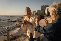 Glückliches Seniorenpaar beim Fotografieren an einem sonnigen Tag — Stockfoto