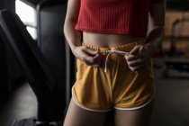 Mid section of woman tying knot of boxer in fitness studio — Stock Photo