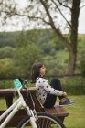 Young girl sitting on bench at garden — Stock Photo