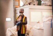 Женщина-работница проверяет время на умных часах на складе — стоковое фото