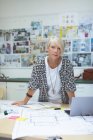 Portrait of female executive standing at desk in office — Stock Photo